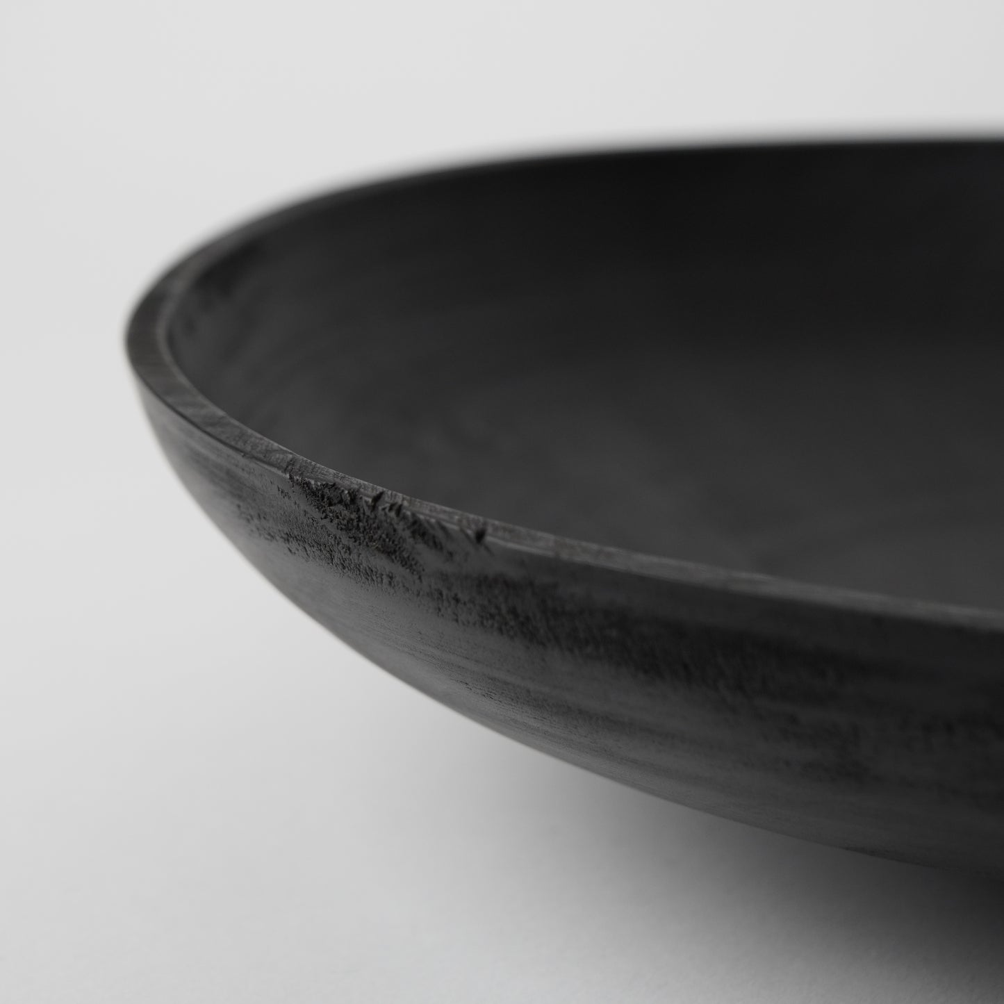 Black wooden bowl on a light gray background