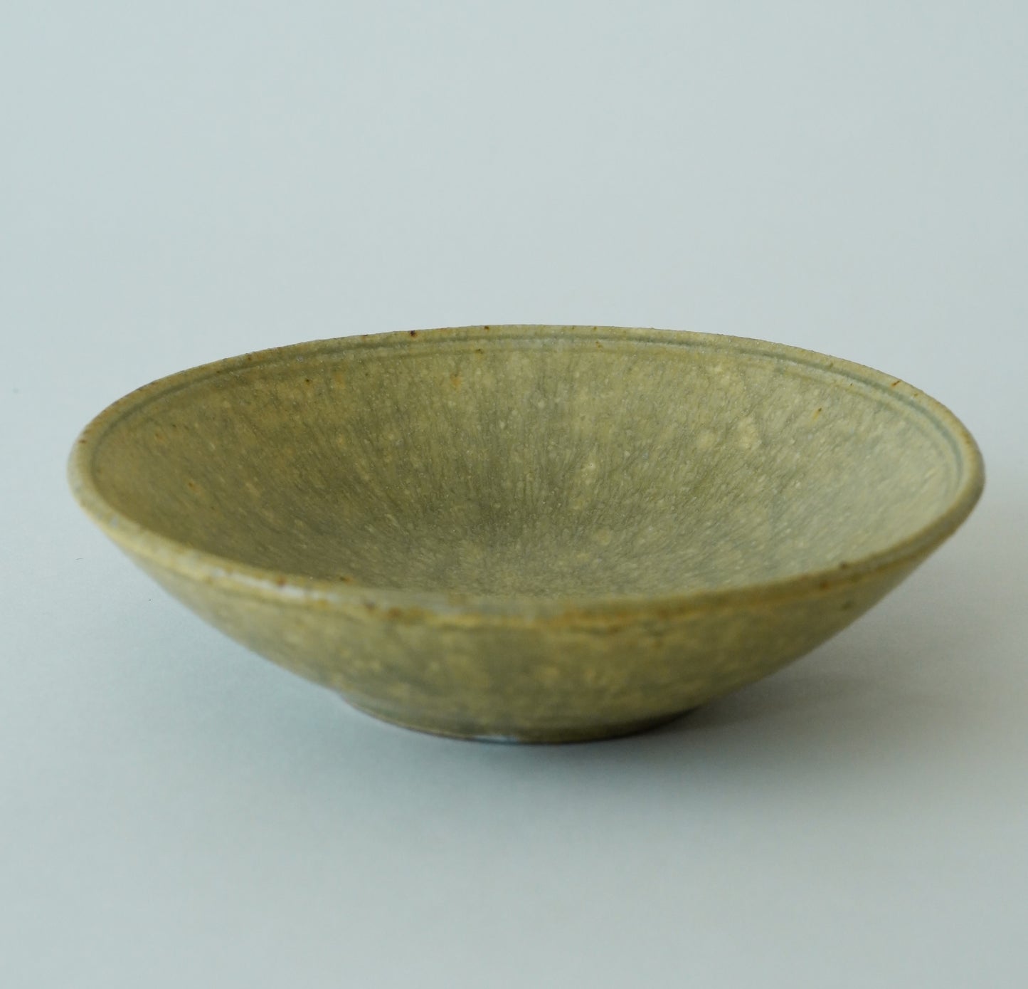 Green ceramic bowl on a light gray background
