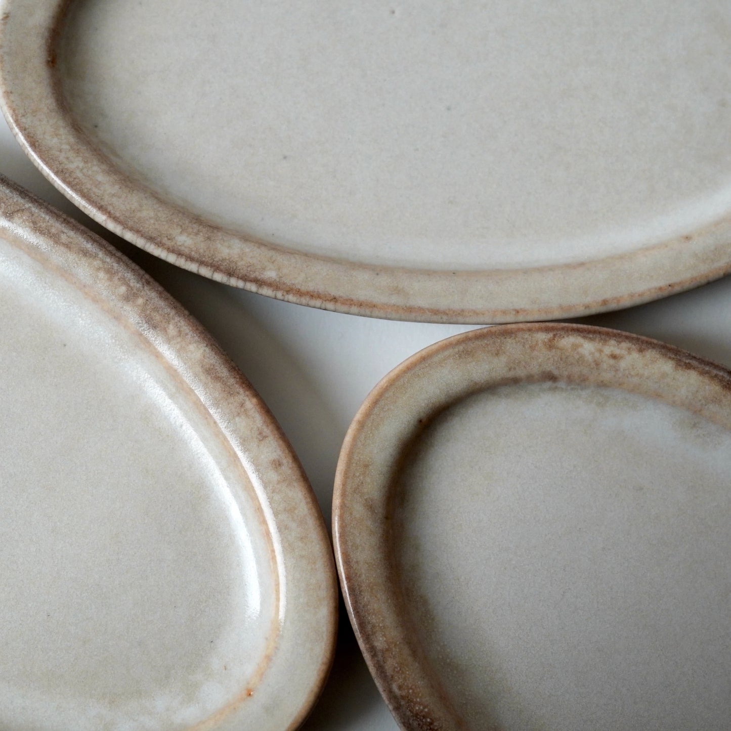 Three ceramic plates with a rustic finish on a white surface