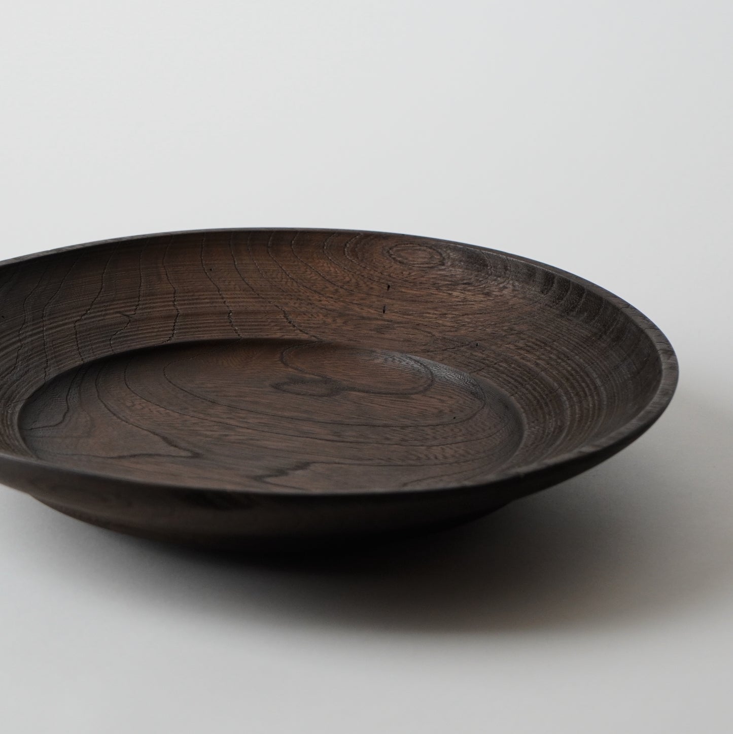 Dark wooden bowl on a light gray background