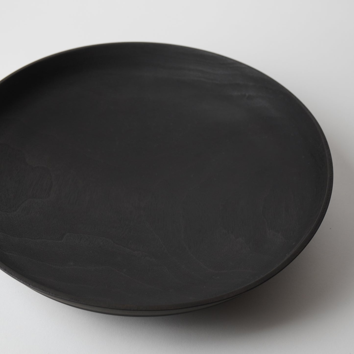 Black wooden plate on a white background