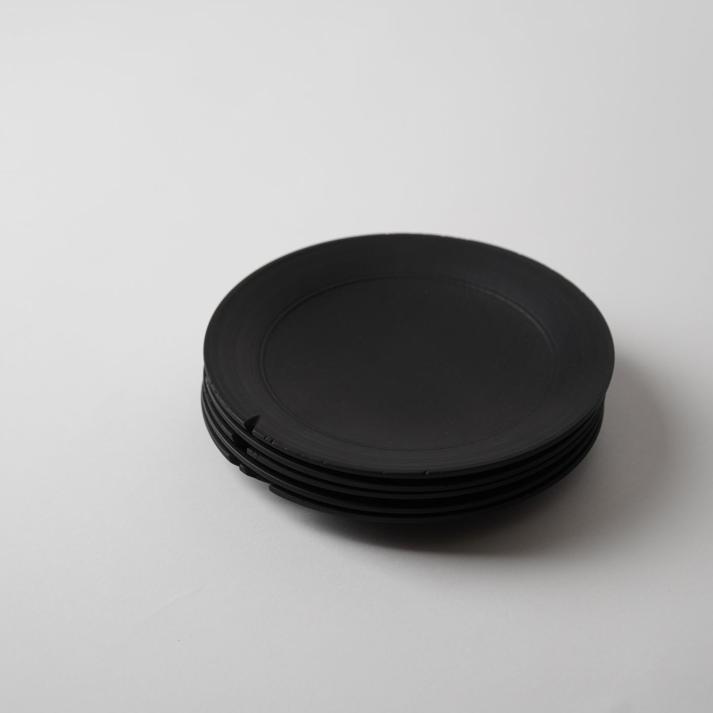 Stack of black plates on a white background
