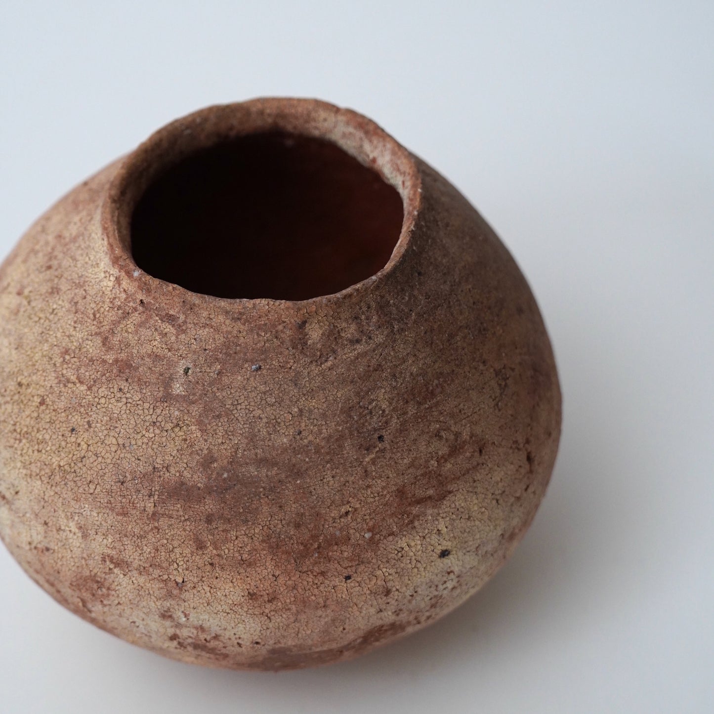 Small brown ceramic pot on a white background