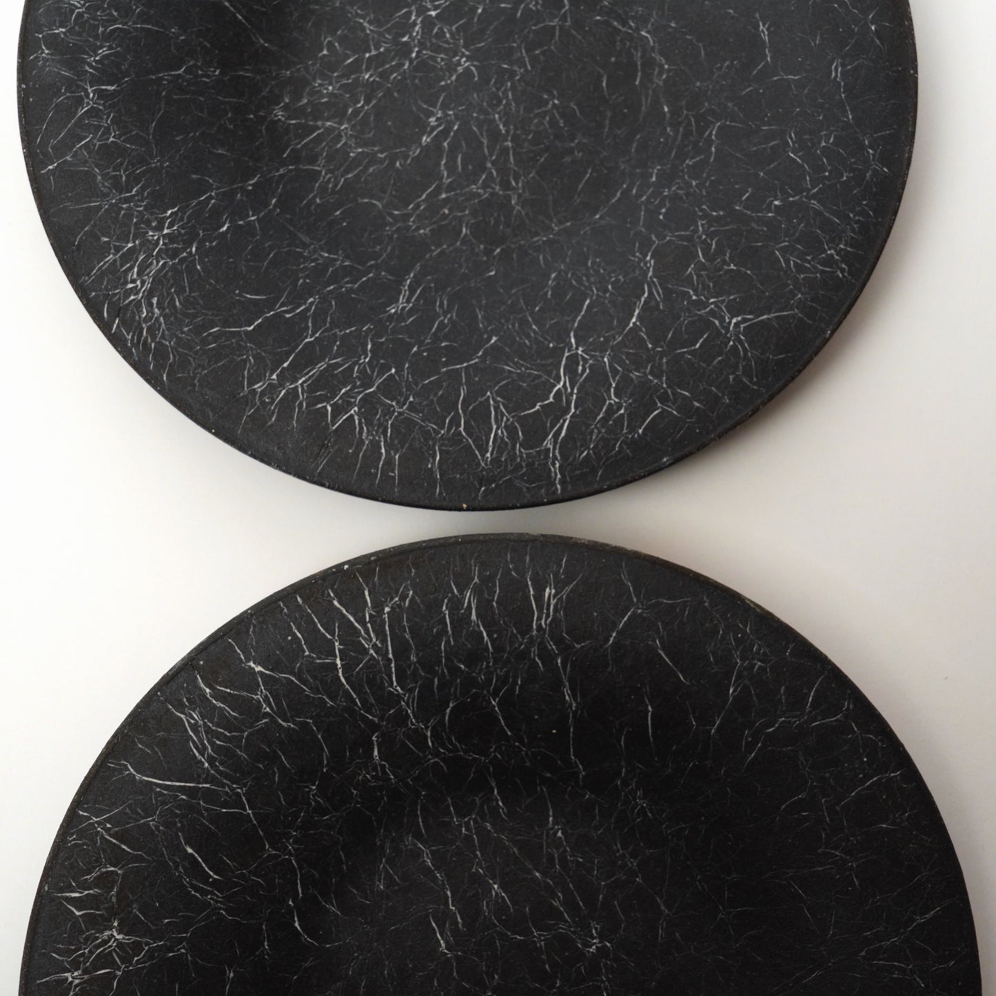 Two black stone plates on a white background