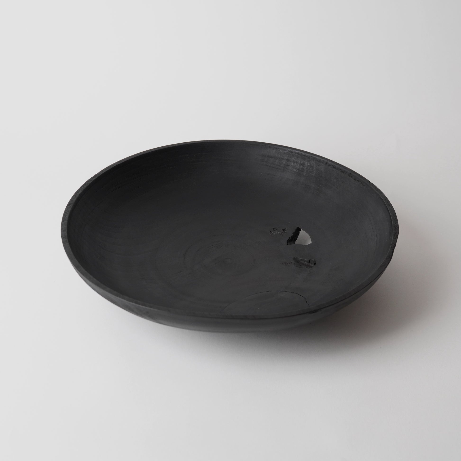 Black wooden plate on a white background