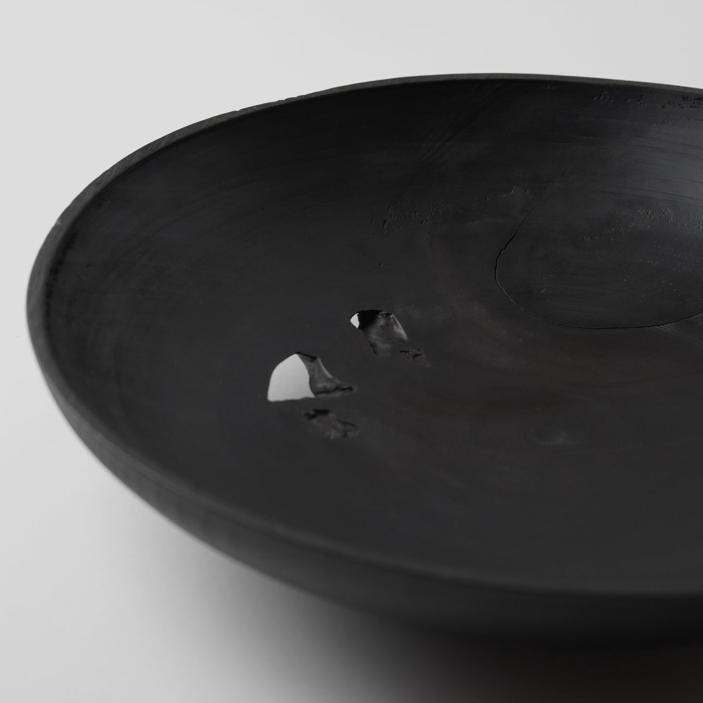 Black wooden bowl on a light gray background