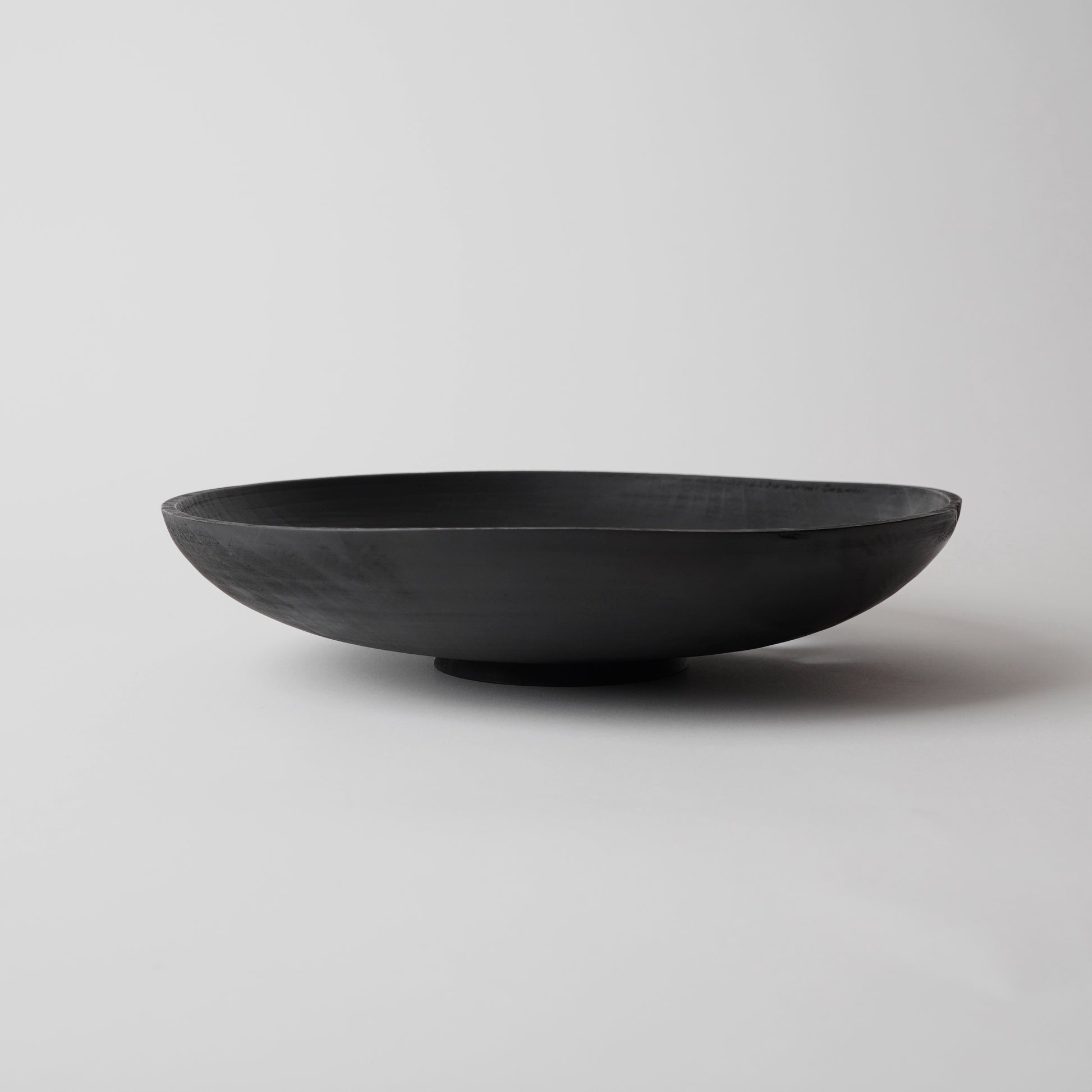 Black wooden bowl on a light gray background