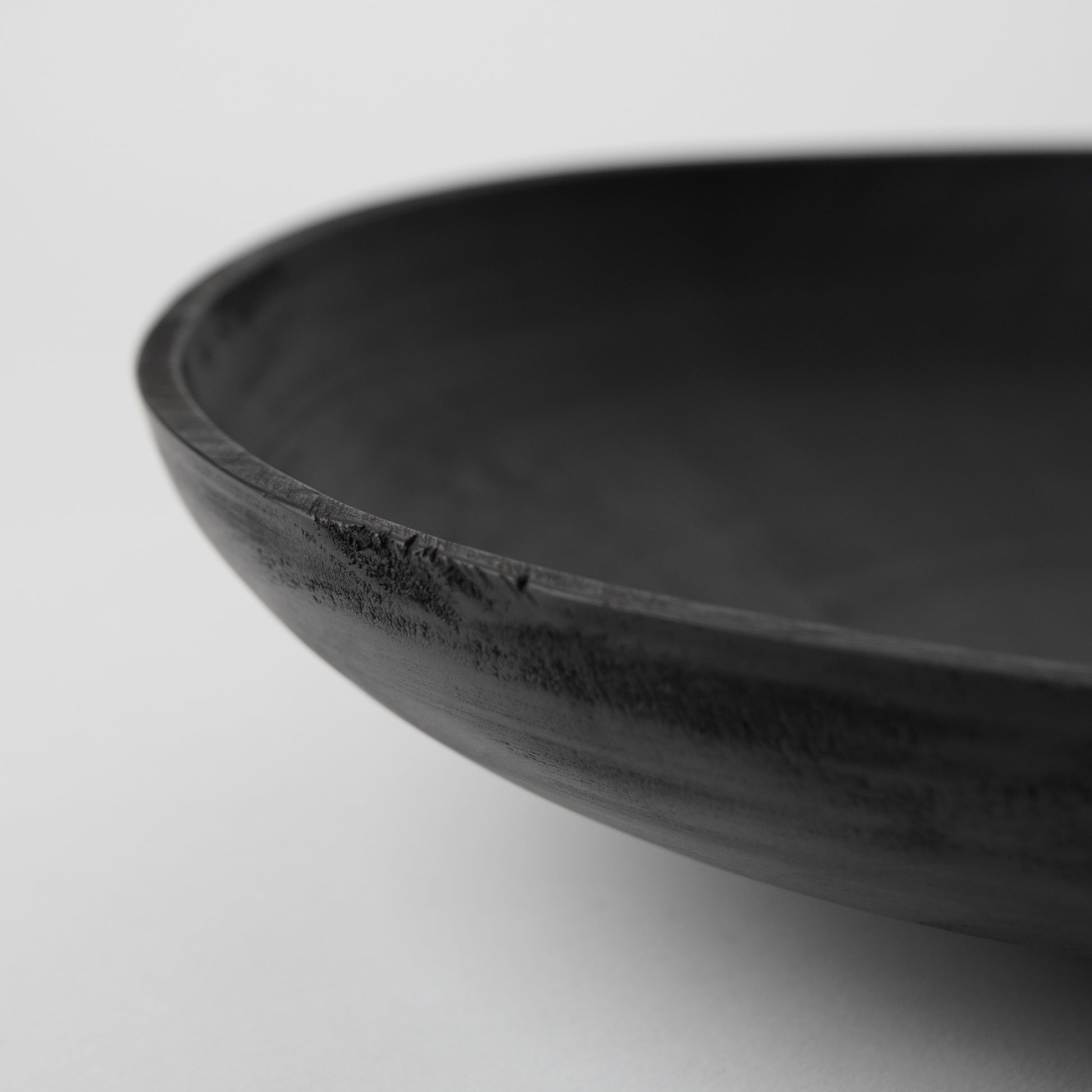 Black wooden bowl on a light gray background