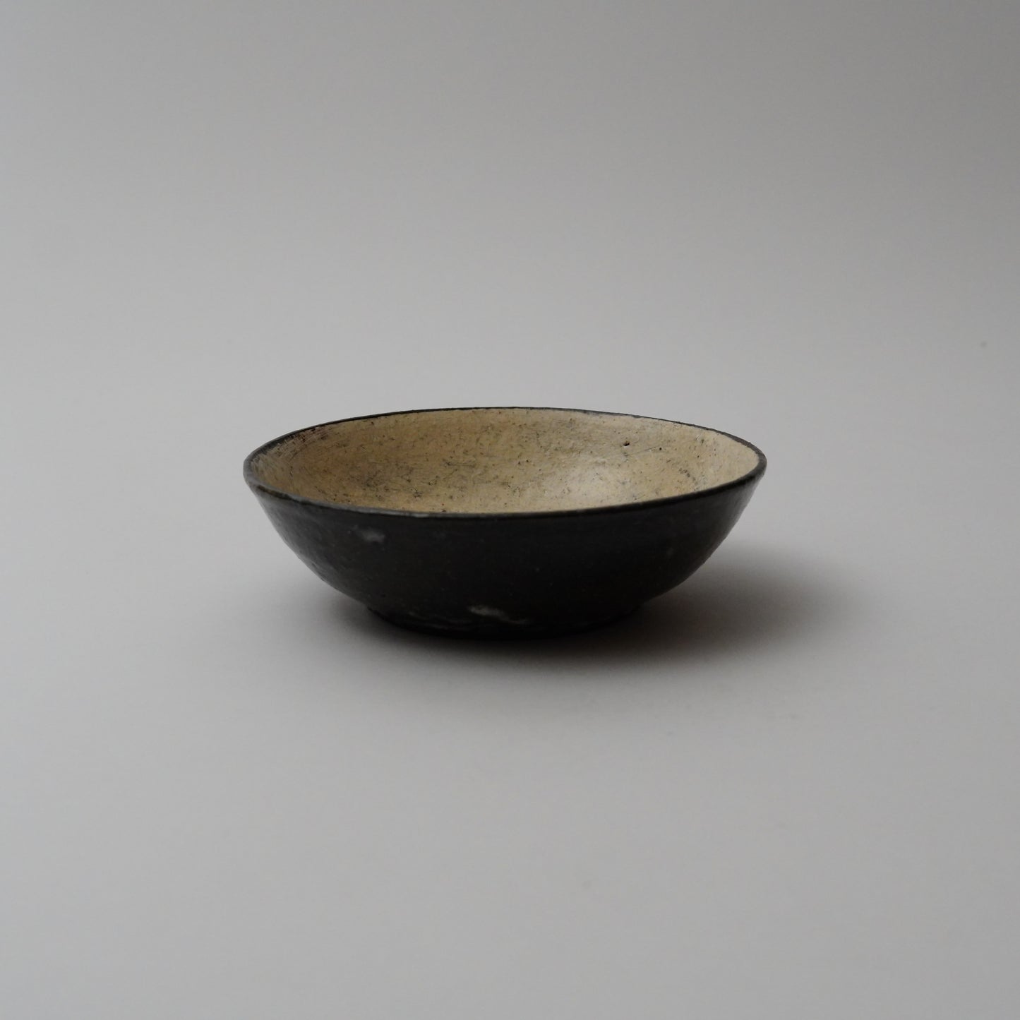 A black ceramic bowl with a smooth finish, displayed against a neutral background