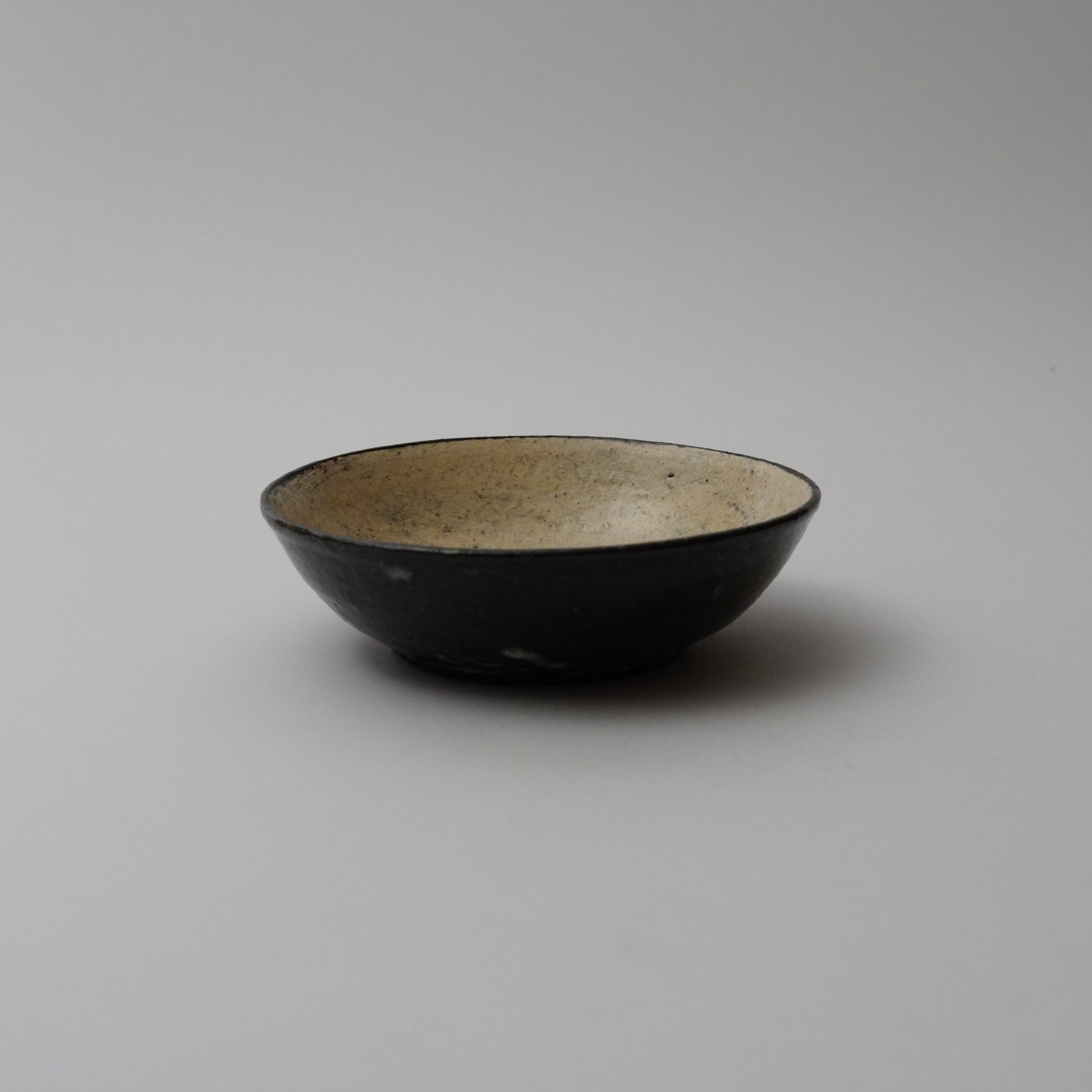 A black ceramic bowl with a smooth finish, displayed against a neutral background
