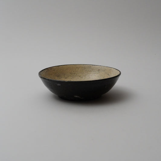 A black ceramic bowl with a smooth finish, displayed against a neutral background