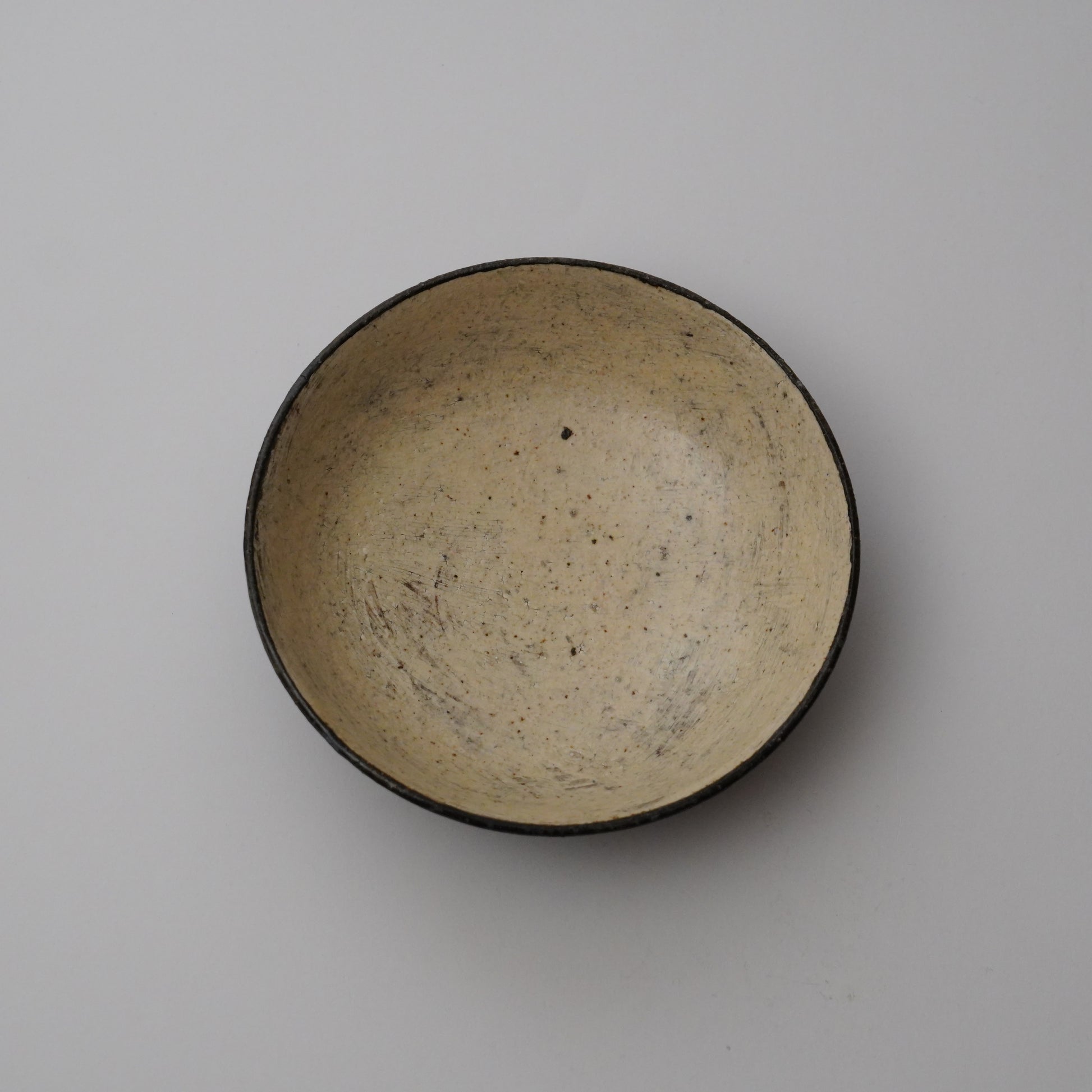 Ceramic bowl with a black interior on a plain background