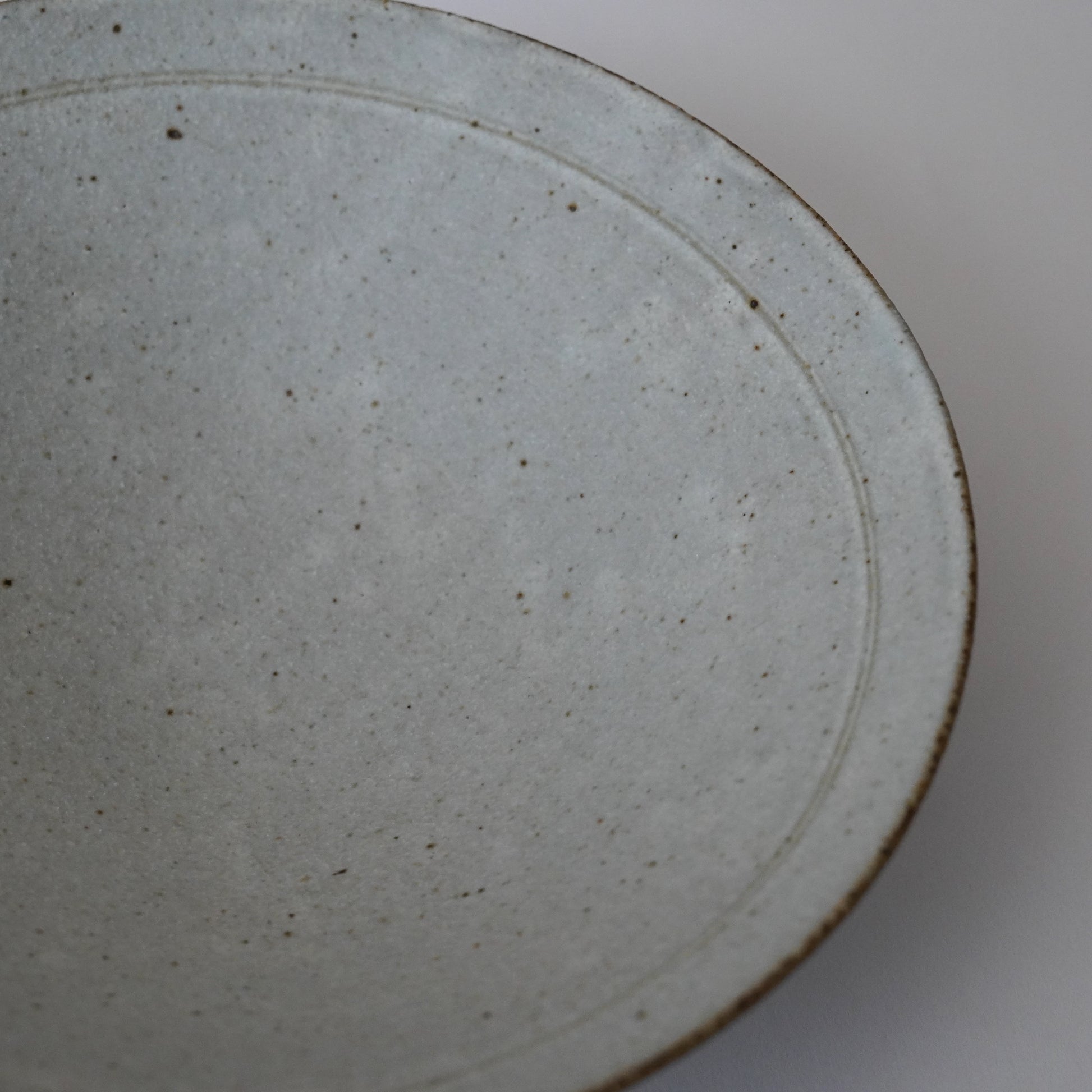 Close-up of a ceramic plate with a textured surface on a white background