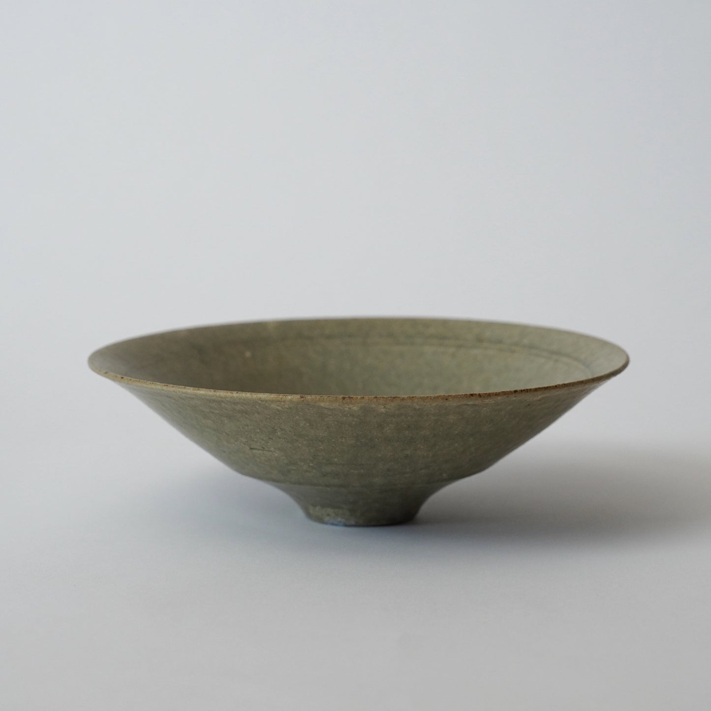 Green ceramic bowl on a light gray background