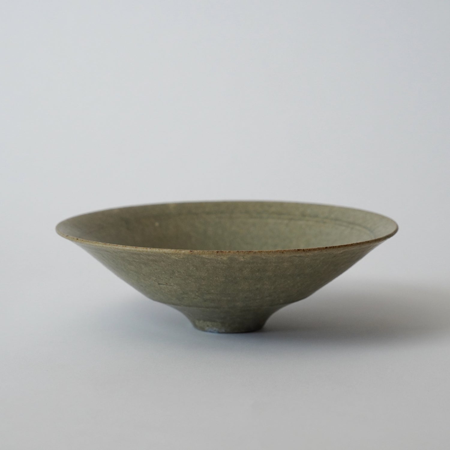 Green ceramic bowl on a light gray background