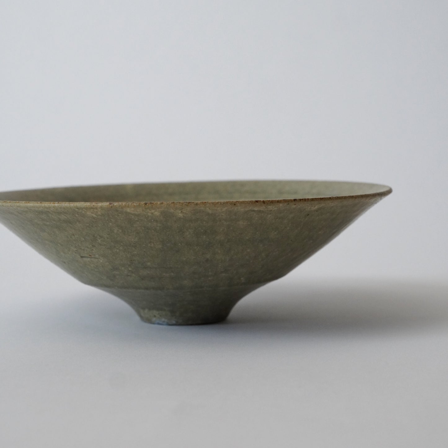 Green ceramic bowl on a light gray background