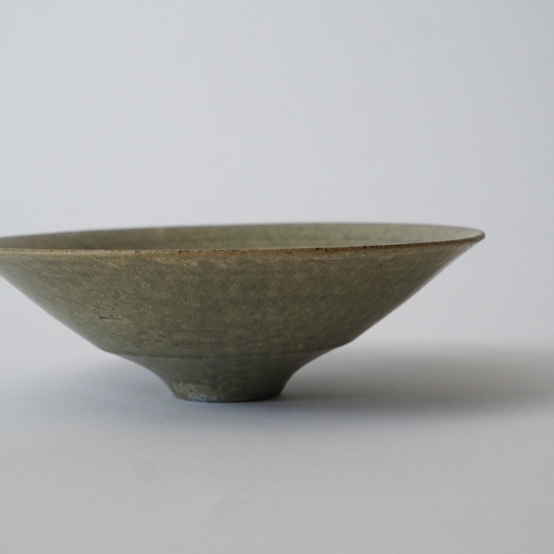Green ceramic bowl on a light gray background