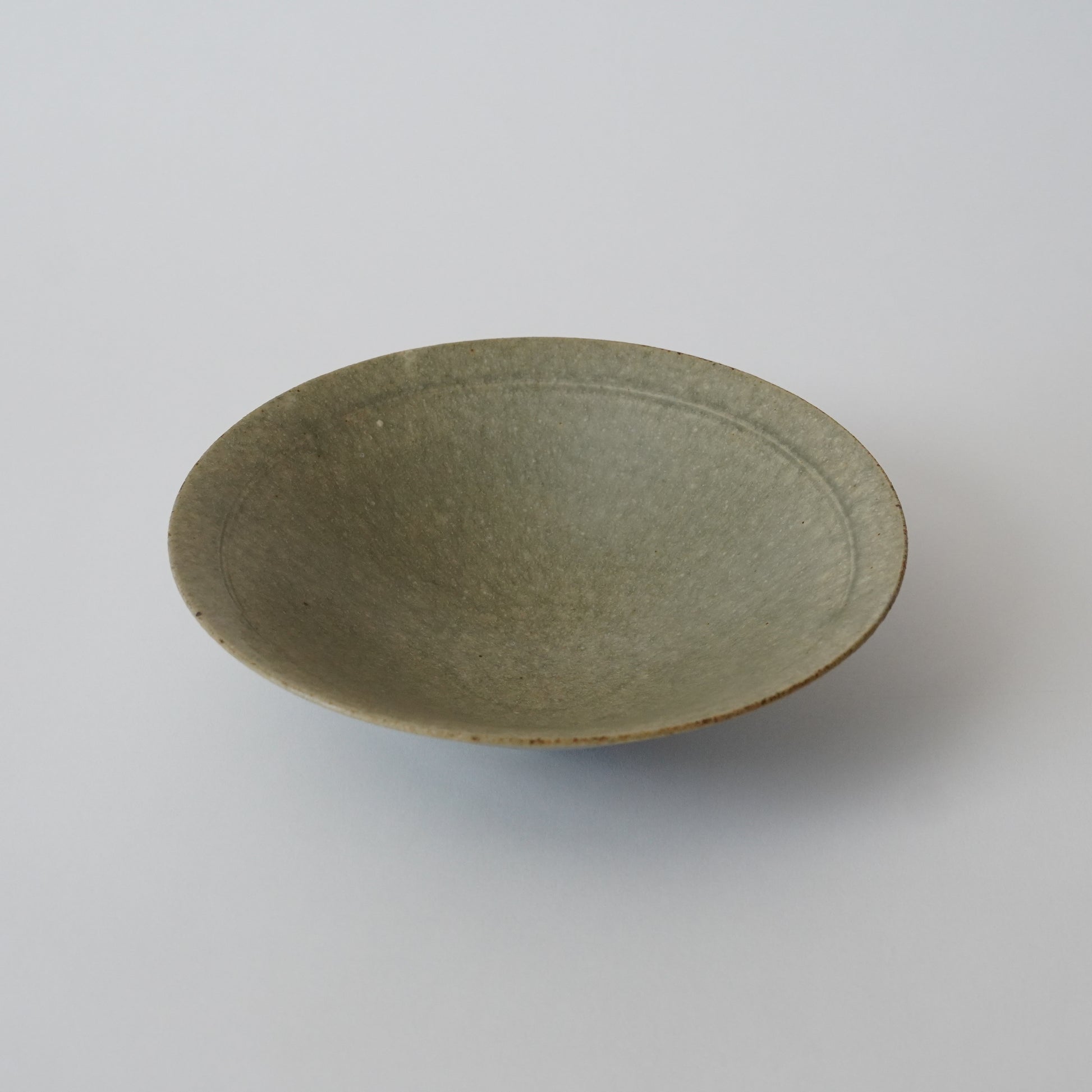 Green ceramic bowl on a white background