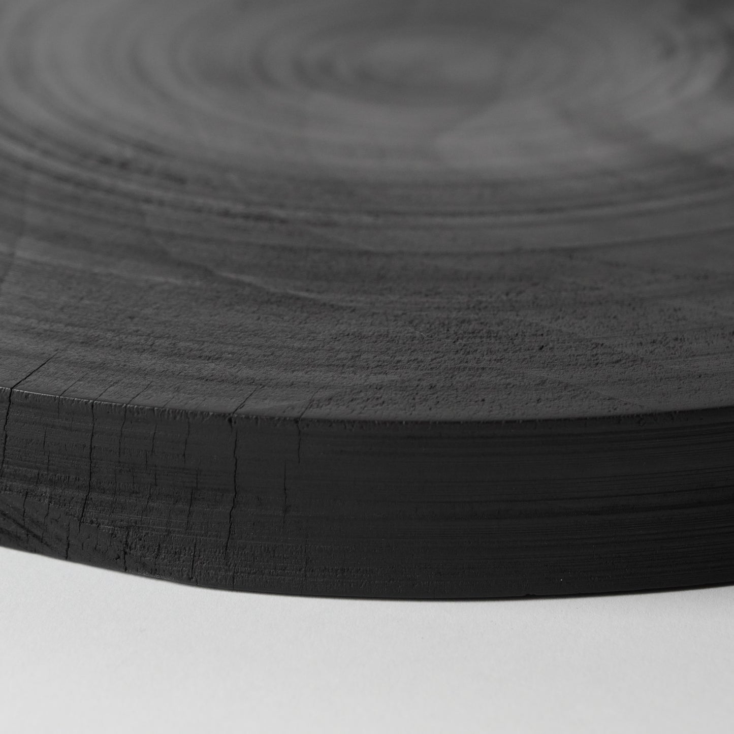 Close-up of a black wooden surface with concentric circular patterns