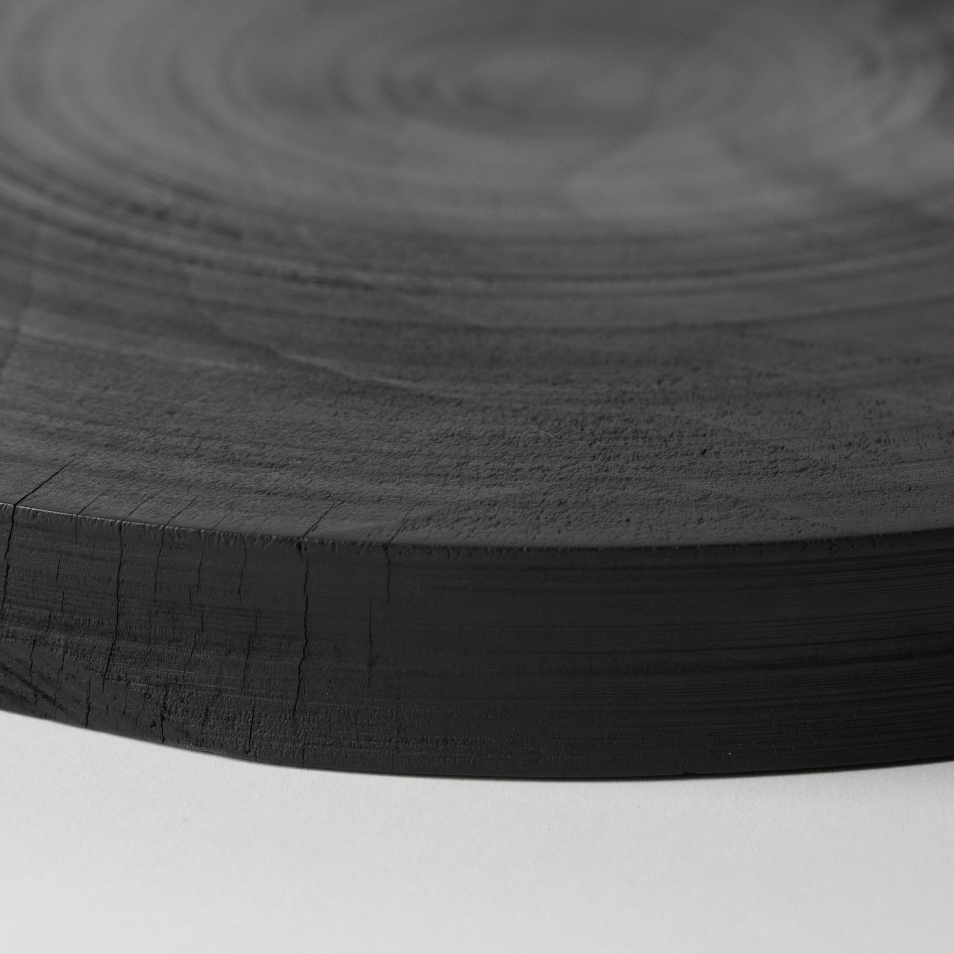 Close-up of a black wooden surface with concentric circular patterns