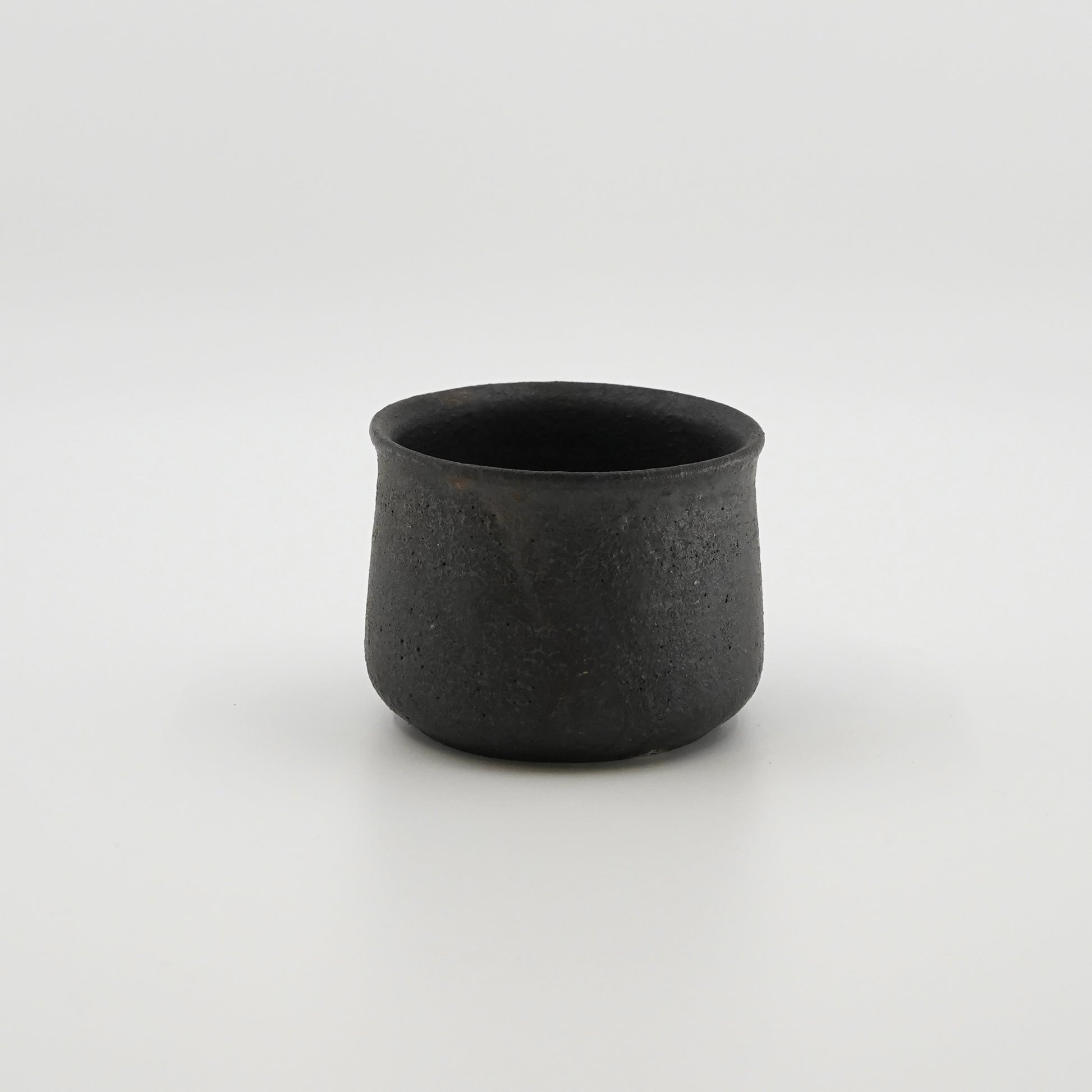 Black ceramic cup on a white background. Handmade ceramic cup by Japanese artist at Gallery tete Hong Kong.