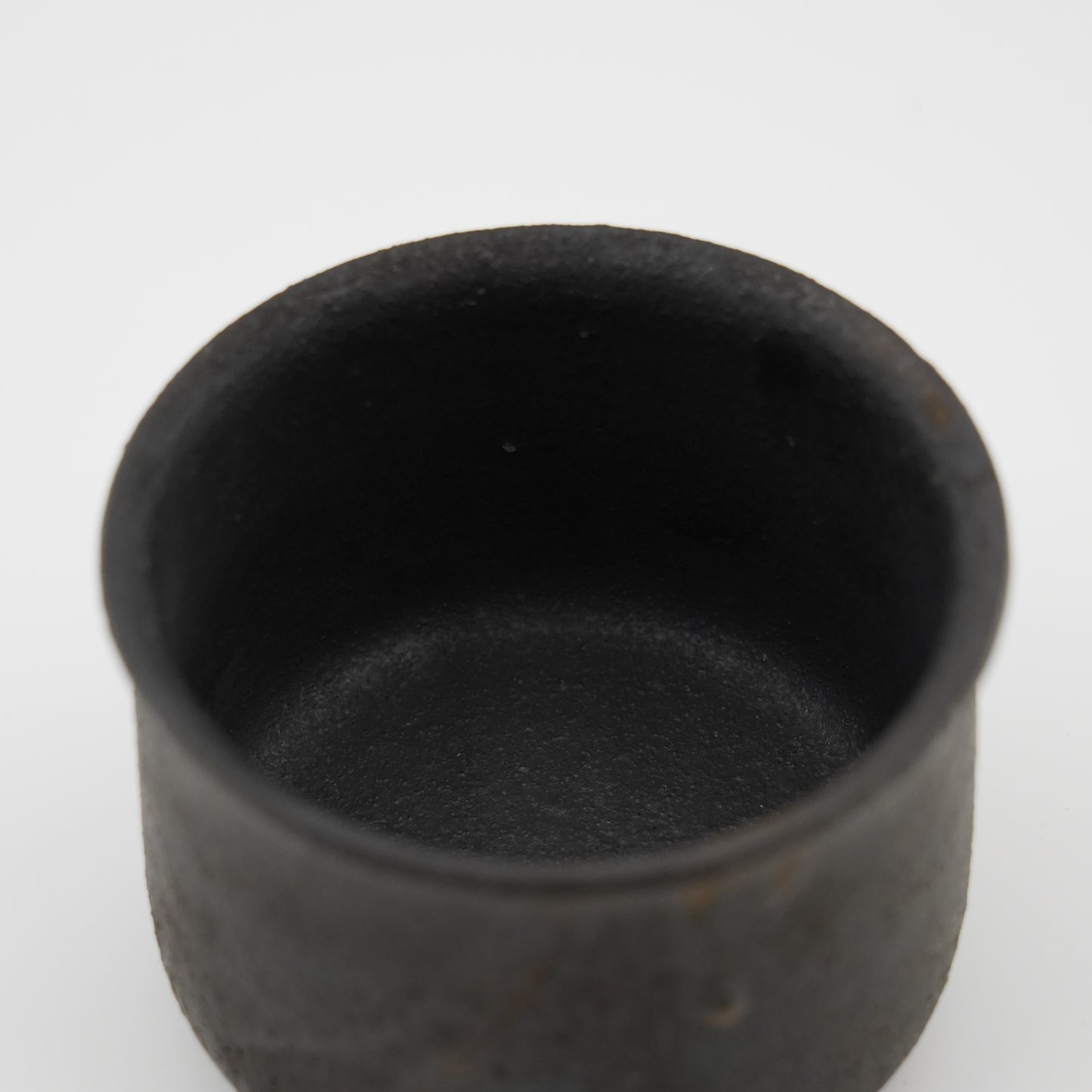 Black ceramic cup on a white background. Handmade ceramic cup by Japanese artist at Gallery tete Hong Kong.