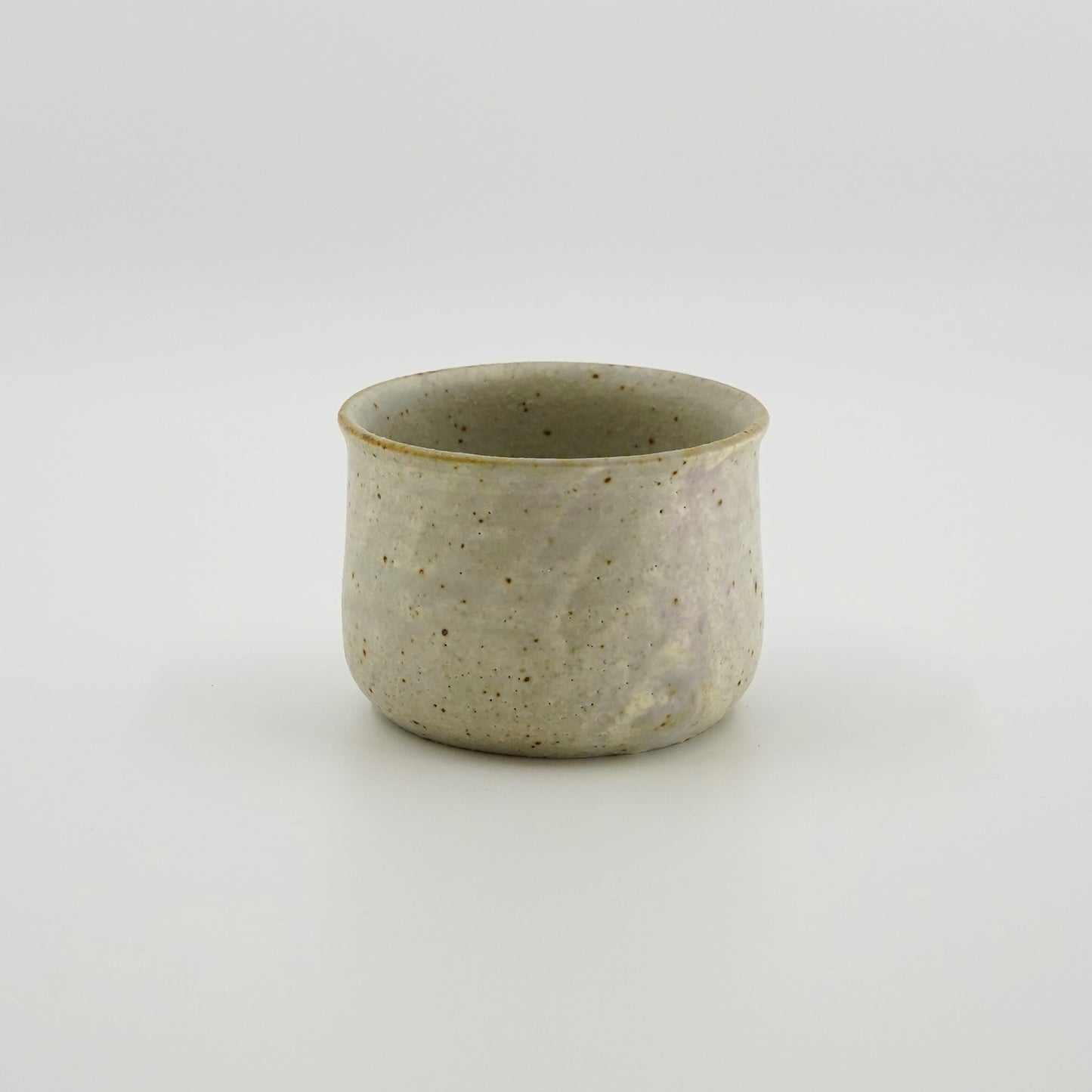 Speckled white ceramic cup on a white background. Handmade ceramic cup by Japanese artist at Gallery tete Hong Kong.