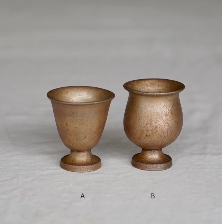 Two bronze-colored goblets on a gray background. Handmade ceramic cup by Japanese artist at Gallery tete Hong Kong.