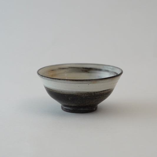 Ceramic bowl with black and white design on a light gray background
