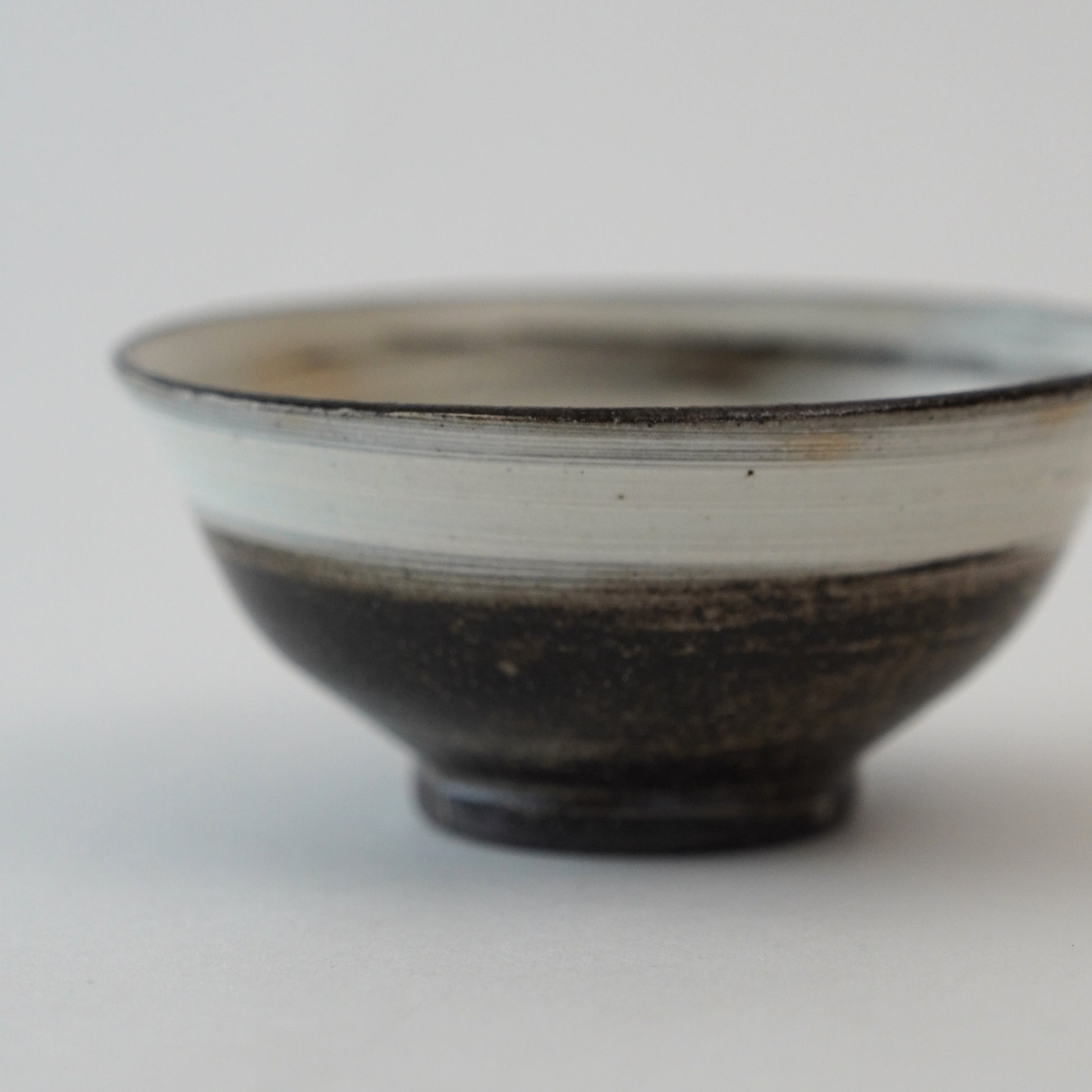 Ceramic bowl with a black and white design on a light gray background