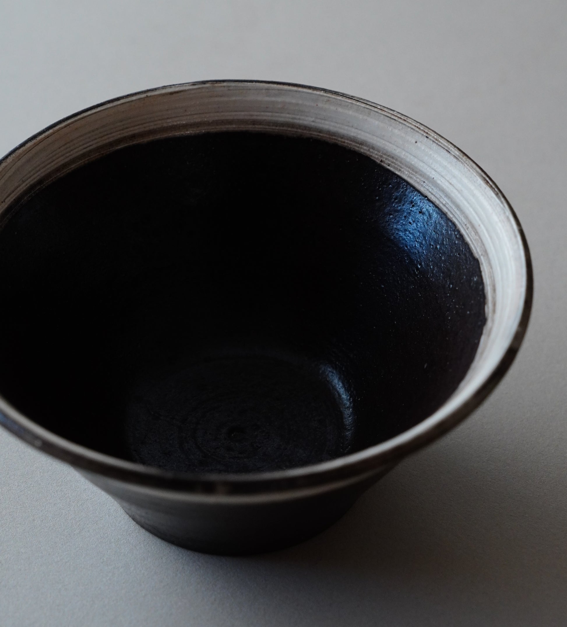 Black ceramic bowl on a gray background