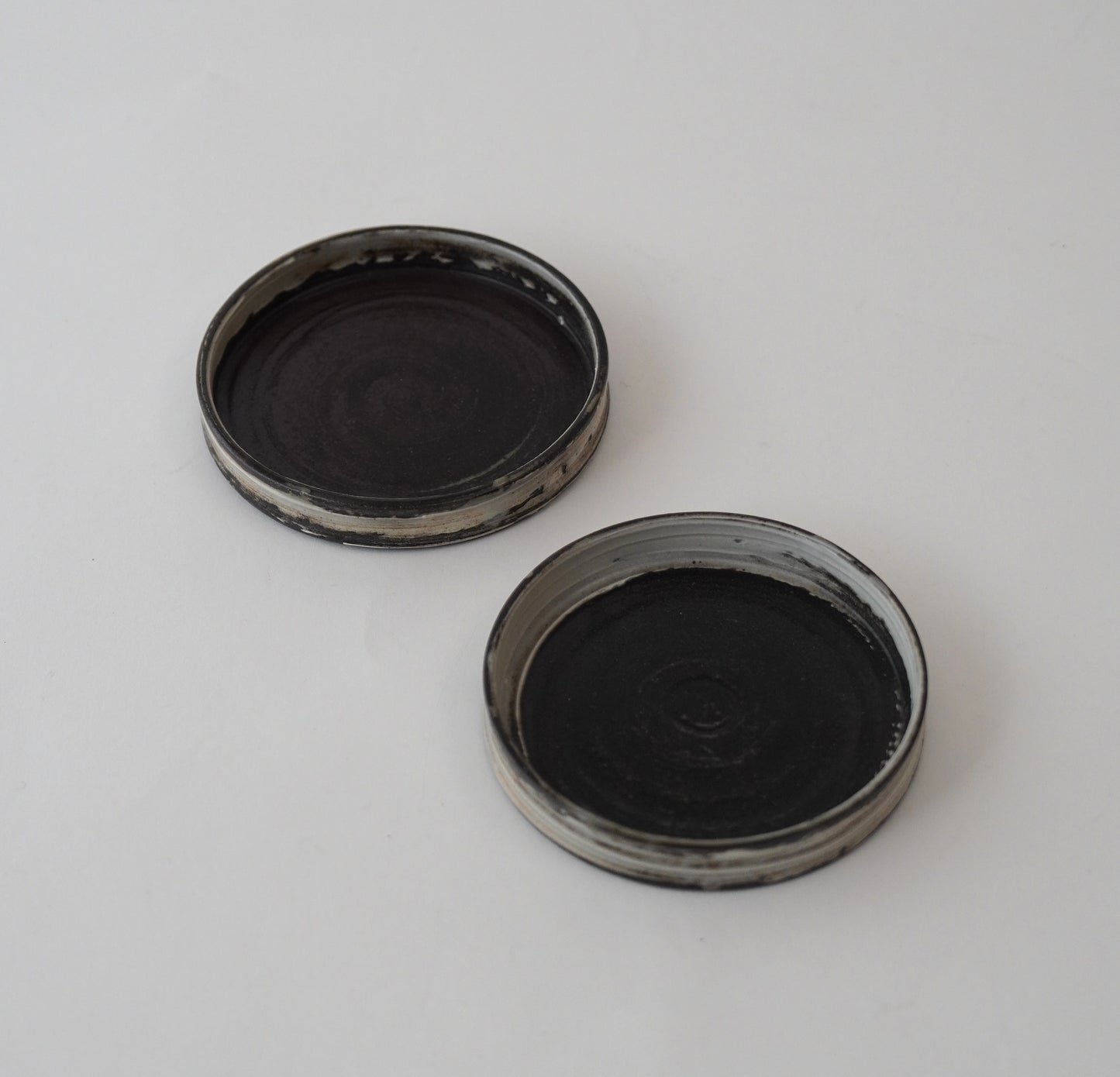 Two black Hakeme small plate on a white background. Handmade ceramic  plate by Japanese artist at Gallery tete Hong Kong.