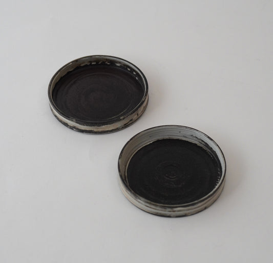 Two black Hakeme small plate on a white background. Handmade ceramic  plate by Japanese artist at Gallery tete Hong Kong.