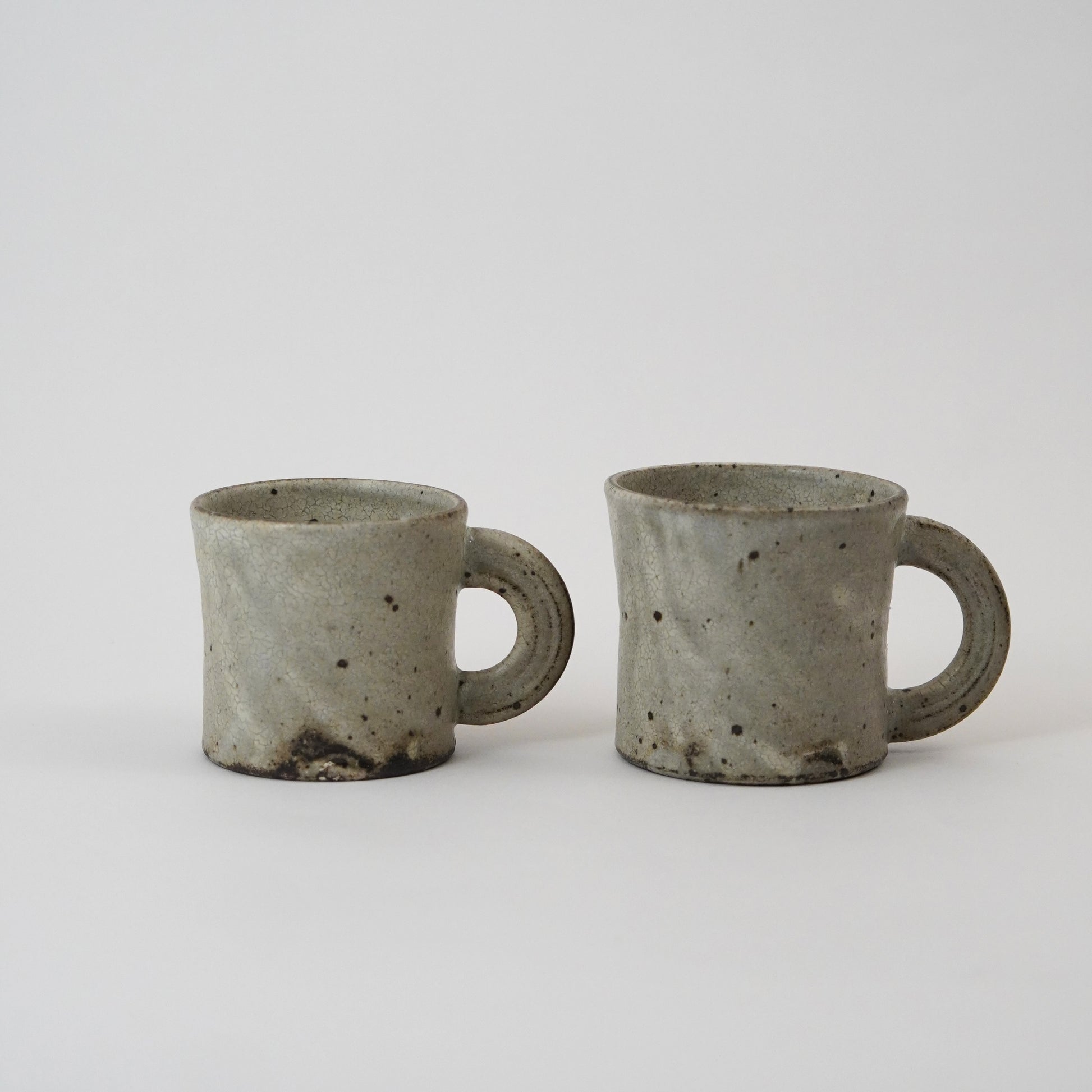 Two gray ceramic mugs on a white background