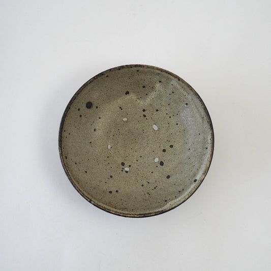 Round ceramic plate with speckled glaze on a white background. Handmade ceramic  plate by Japanese artist at Gallery tete Hong Kong.