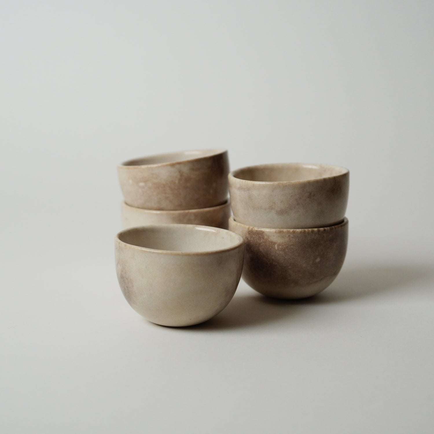 Set of four ceramic bowls stacked on a light gray background