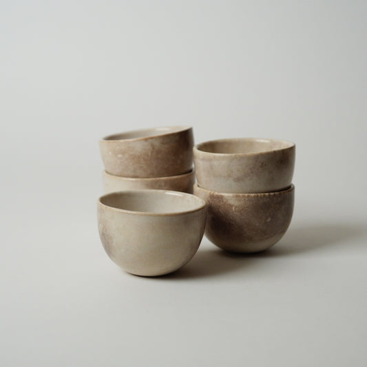 Set of four ceramic bowls stacked on a light gray background