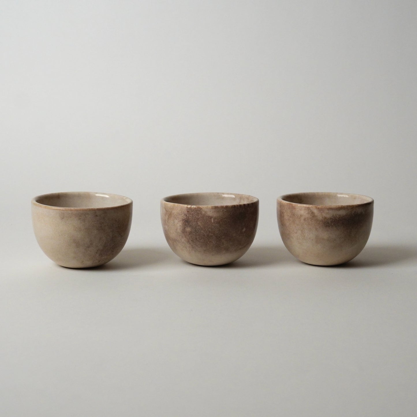 Three ceramic bowls of varying sizes on a plain background