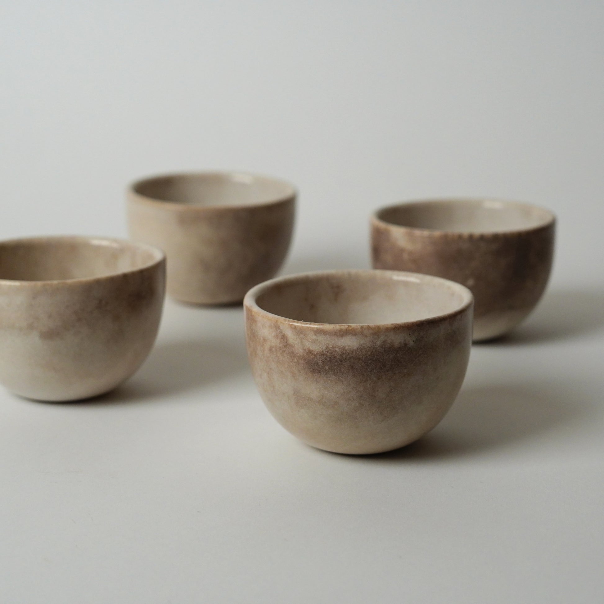 Four ceramic bowls of varying sizes on a light gray background