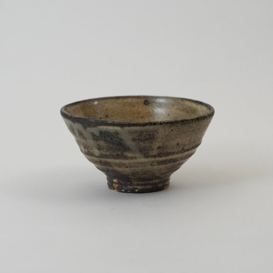 Small ceramic bowl with a brown glaze on a white background