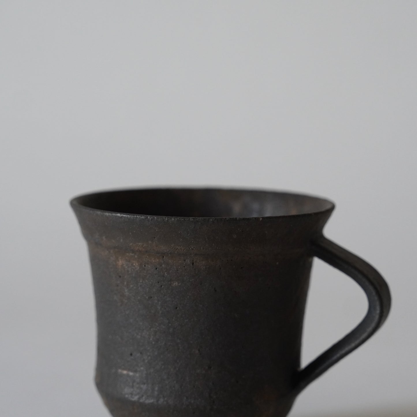 Black ceramic mug on a light gray background