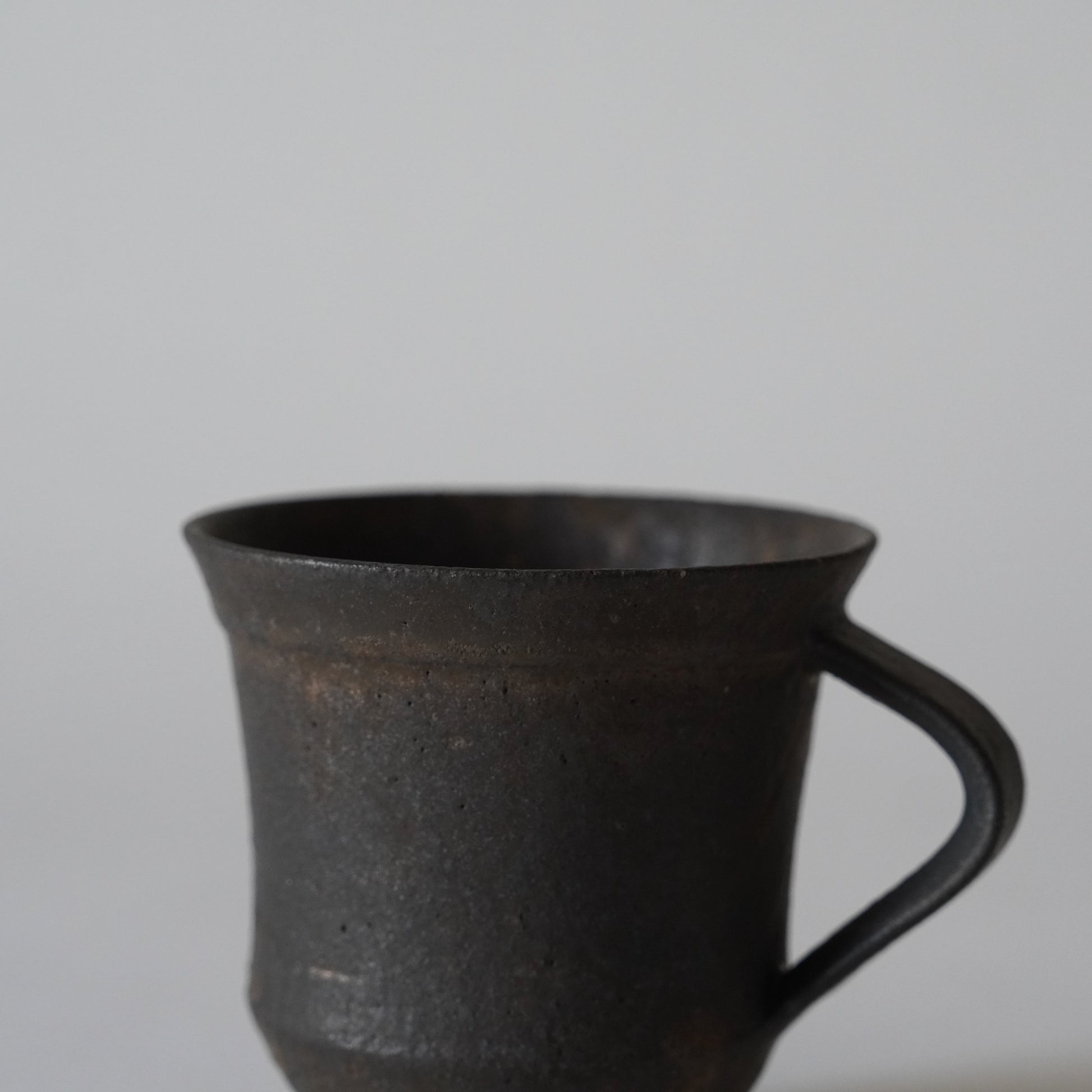 Black ceramic mug on a light gray background