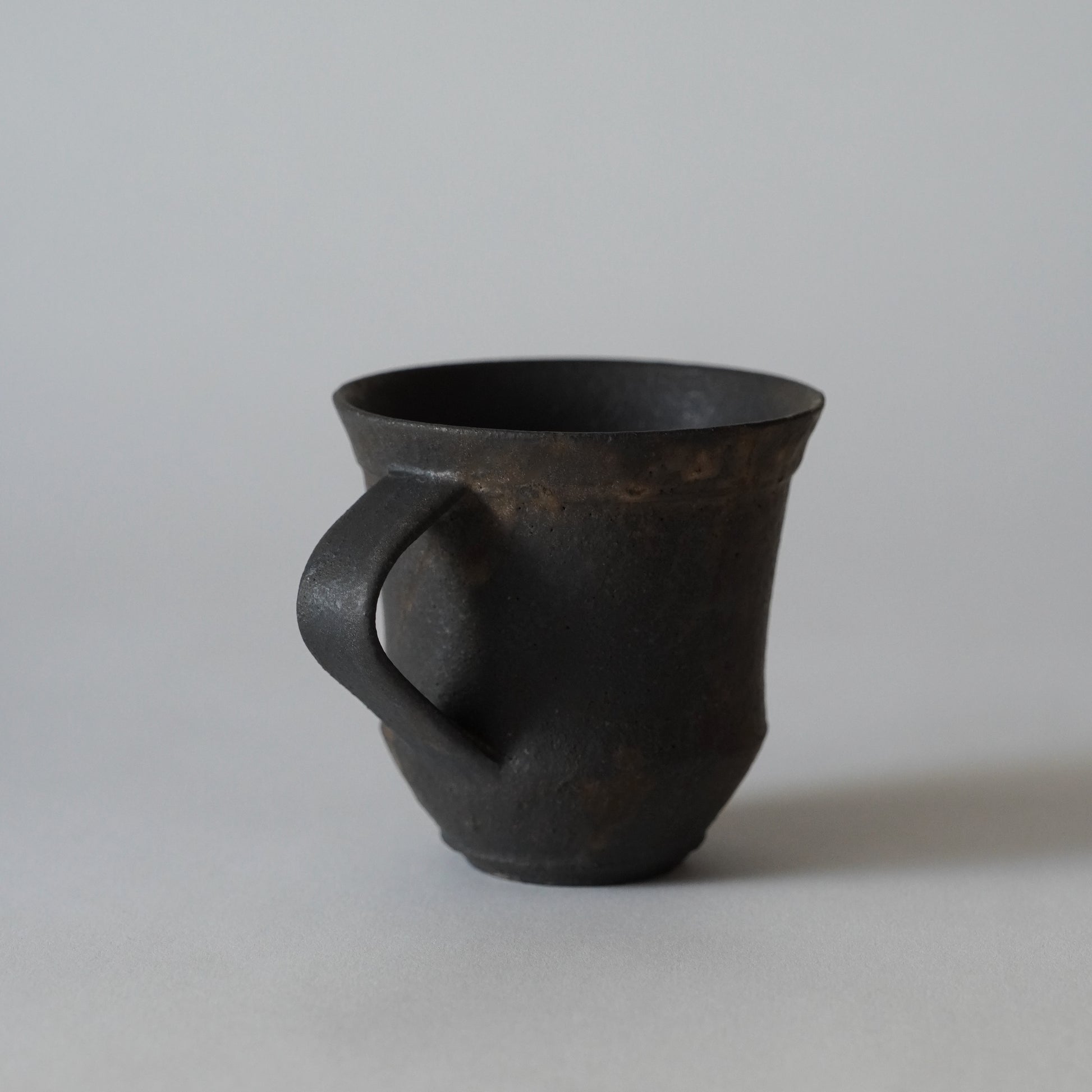 Black ceramic mug on a light gray background