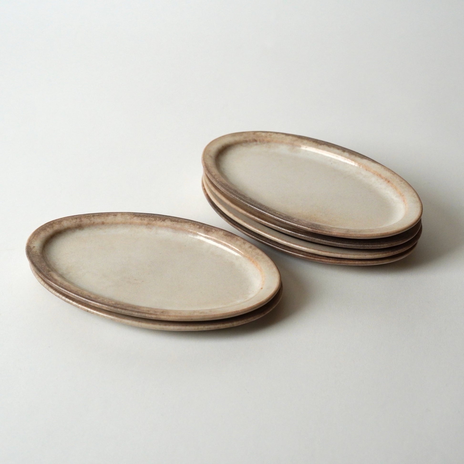 Set of ceramic plates with a rustic finish on a light gray background