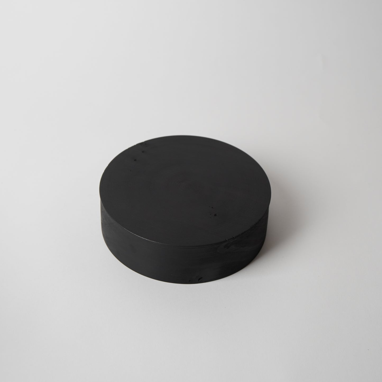 Black cylindrical object on a white background