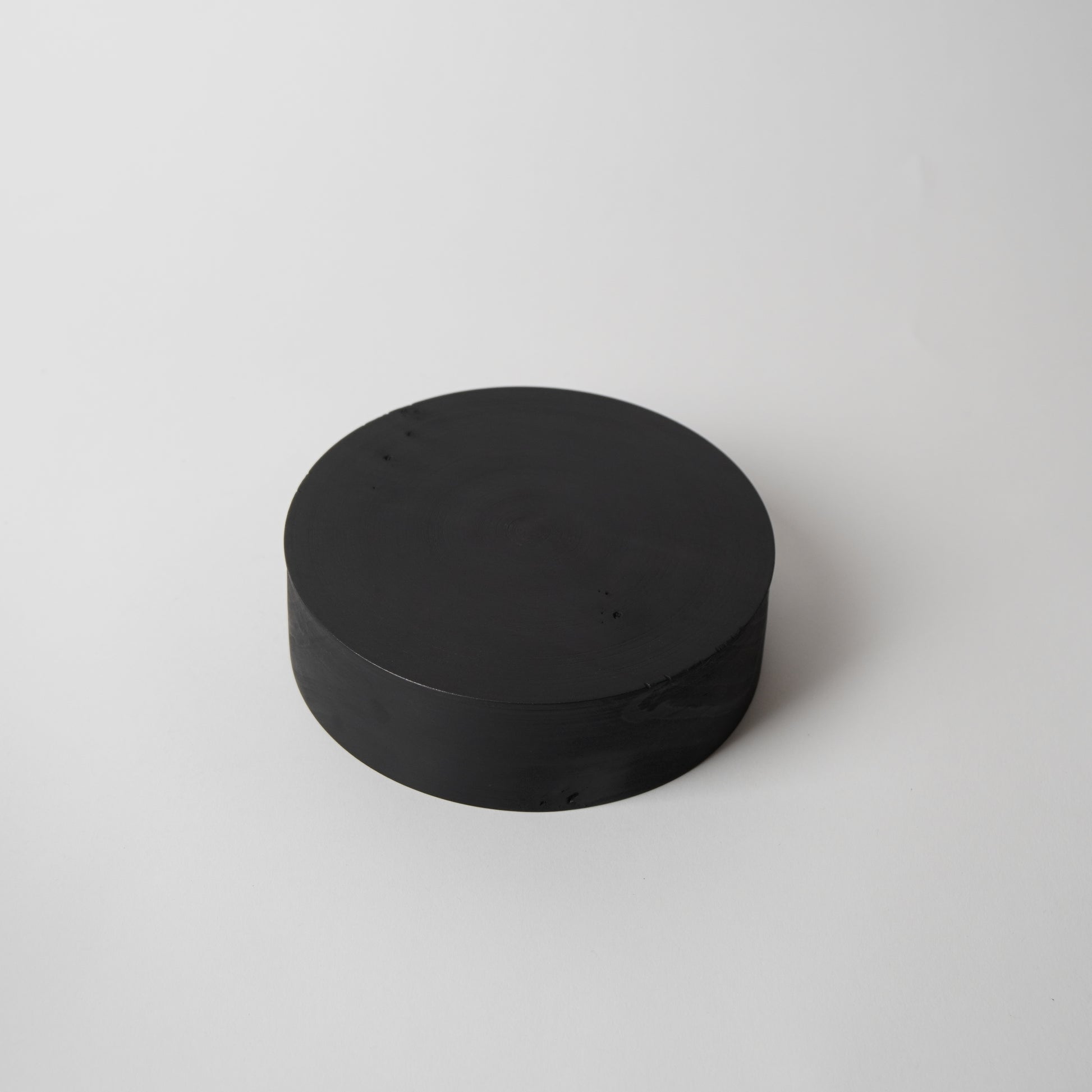 Black cylindrical object on a white background