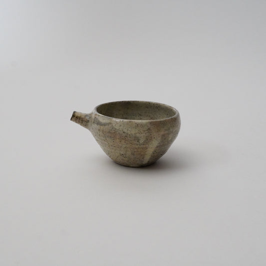A gray ceramic pitcher with a textured finish on a white background.