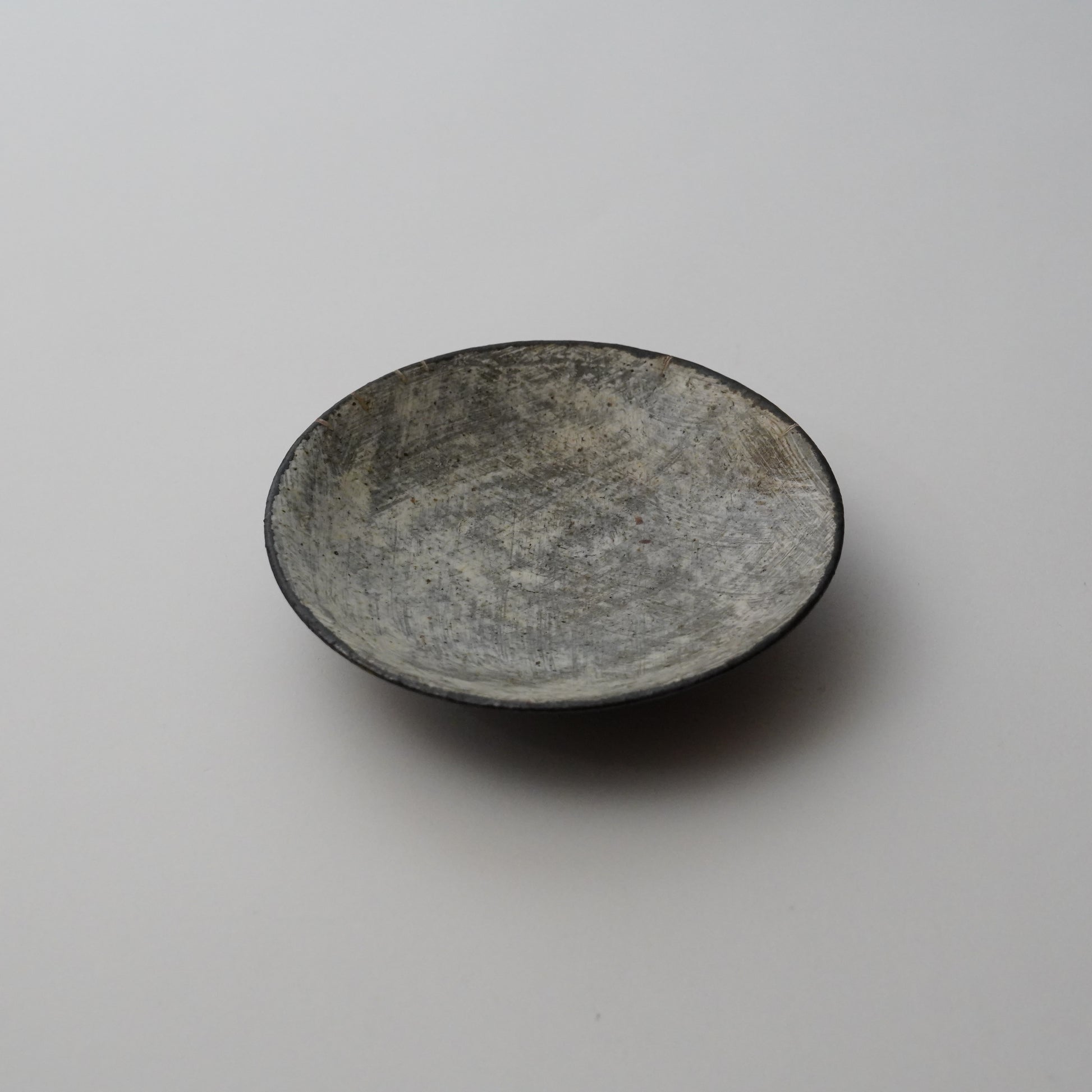 Small ceramic bowl with a textured surface on a plain background