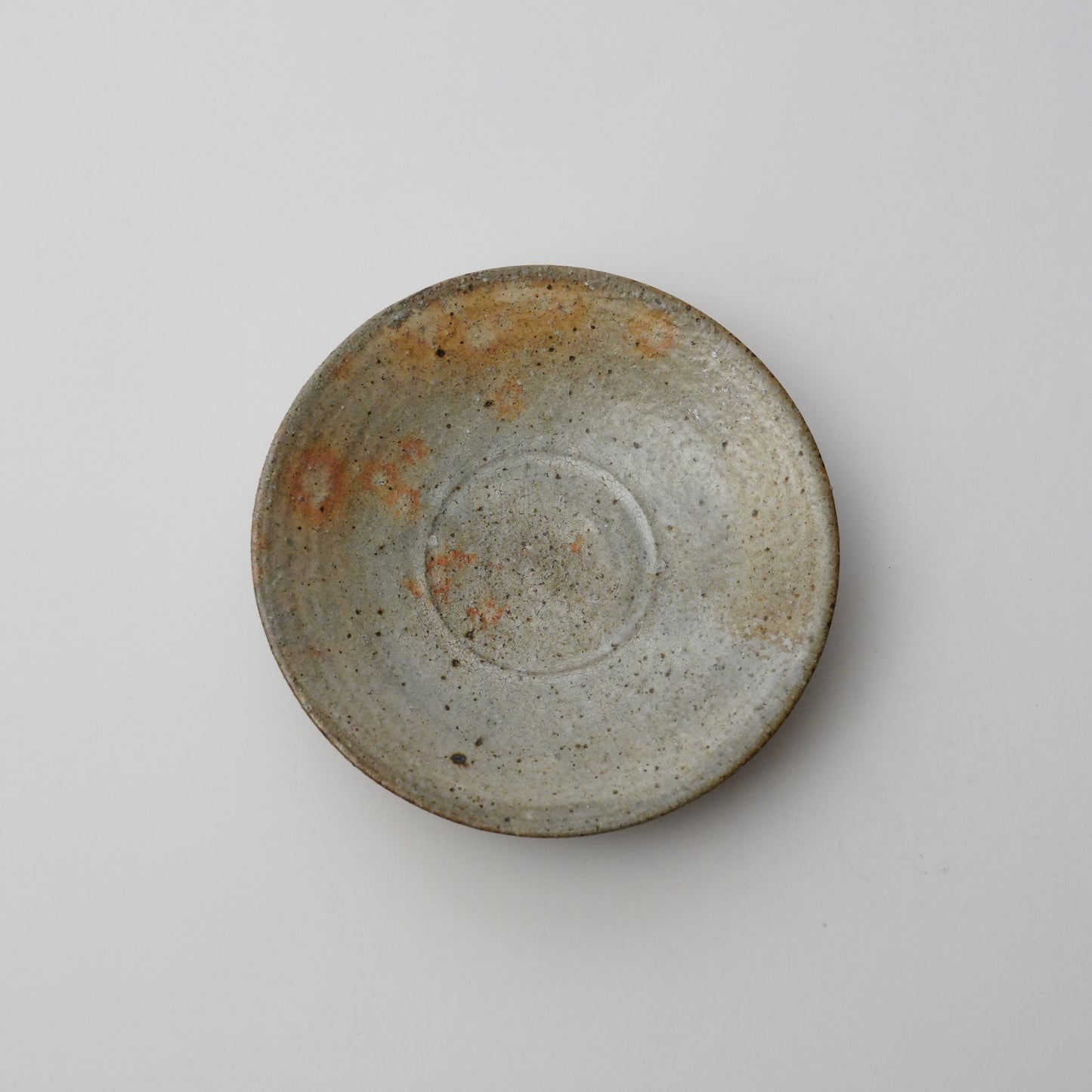 Ceramic bowl with a raw, unglazed finish on a neutral background. Handmade ceramic  plate by Japanese artist at Gallery tete Hong Kong.