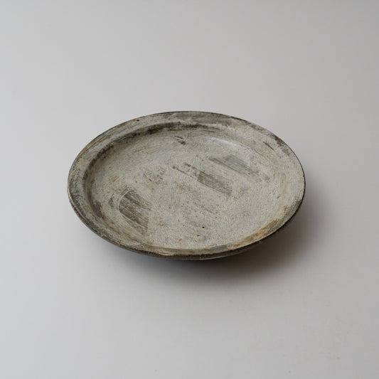 A gray ceramic plate with a simple design, displayed against a white background.